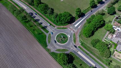 Aerial shot of an unfinished street on a roundabout with cars in a residential area neighborhood in Steenwijk, Overijssel, The Netherlands. © Laura