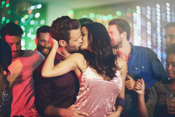 Couple, kiss and dance in club at night on date with love in relationship. People, hug and embrace...