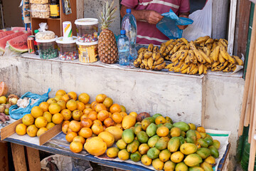 Street vendor, person and selling fruit for profit with vitamin c, health and shopping for organic grocery. Food, vegetables and entrepreneur with banana for nutrition and outdoor market in Brazil