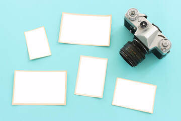 top view of blank photo frames over pastel blue background.