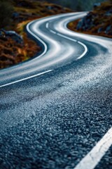 A winding road in the mountains, perfect for travel and adventure concepts