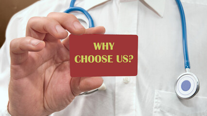 Business and Why choose us concept. Copy space. Why choose us symbol on a business card, a card in the hand of a man in a white shirt with a stethoscope around his neck