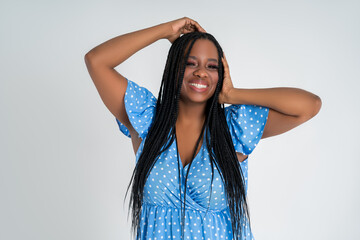 Happy plus size black model in blue dress, African woman with curvy figure and pigtailed hairstyle,...