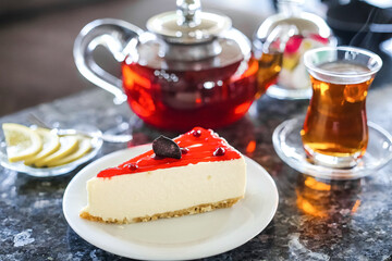 A Piece of Cheesecake on a Plate With a Cup of Tea