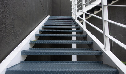 A staircase with a metal railing and a grey color