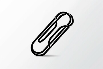 Obraz premium Simple black paper clip casting a shadow on a white surface. Ideal for office and stationery concepts