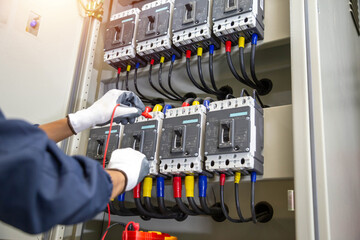 Electricity and electrical maintenance service, Engineer hand holding AC voltmeter checking electric current voltage at circuit breaker terminal and cable .	
