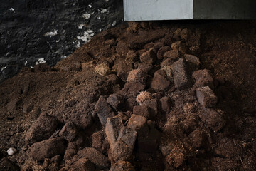 Dried lumps of peat in a whisky distillery. Peat is used to dry the malted barley. It gives the...