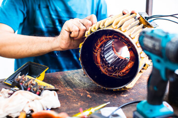 Copper windings inside an electric motor. The mechanic is repairing an electric motor by replacing...
