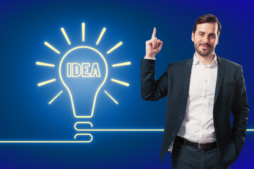 A man in a suit points upwards, neon light bulb with the word IDEA on a blue background, concept of innovation