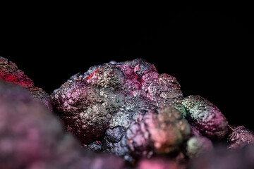 colorful iridescent goethite macro photography detail texture black background. close-up raw rough...
