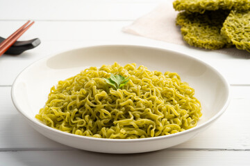 Boiled japanese style green noodles,Cooked dry instant vegetable noodle,Jade noodles made from spirulina seaweed in white plate.