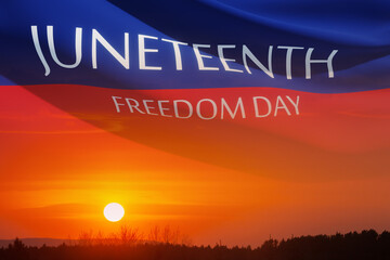 Fluttering banner with text Juneteenth Freedom Day on the wind on background of sunrise or sunset....