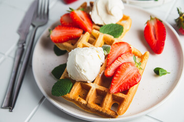 Belgian waffles with strawberries and ice cream