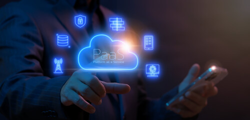 PaaS, Platform as a Service concept. Cloud computing service on software platform. Businessman working with smartphone to operate cloud PaaS icon on virtual screen.