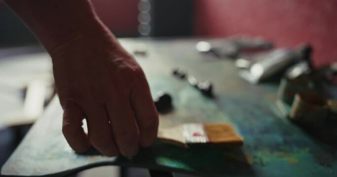 Close-up of paint and brush on artist's table. 