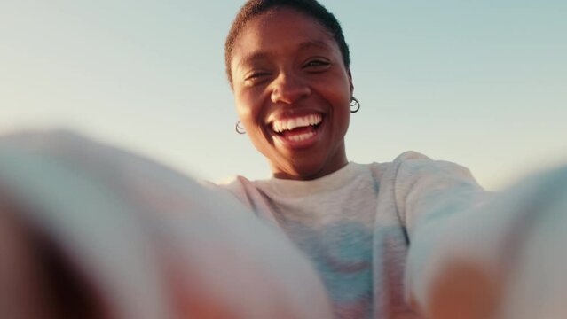 Portrait of a happy girl smiling, taking a selfie and twirling around with camera in hands