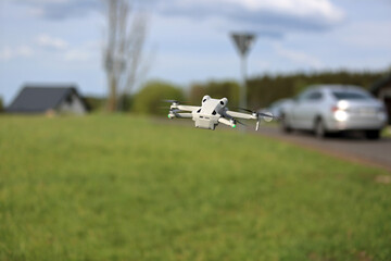 Dron w locie, w powietrzu, samochody osobowe na drodze, budynek jednorodzinny. © Stanisław Błachowicz