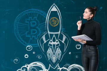 A woman contemplating a chalk-drawn rocket with Bitcoin symbol, expressive of startup and crypto...
