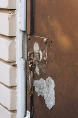 Metal old peeled rusty doors with a key in the keyhole. Photography, retro architecture concept.