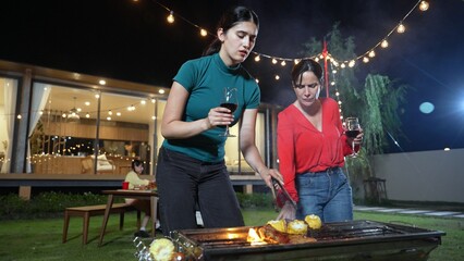 Family gather celebrate holiday. Focus Mother and grandmother drink wine and grill food for family...