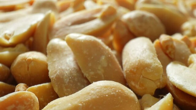 Indulge in the allure of roasted peanuts, their golden-brown shells cracked open to unveil smooth, glossy interiors. Each half, adorned with delicate salt crystals, promises a savory delight.
