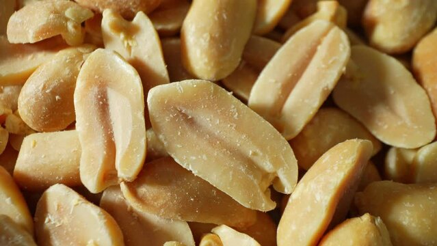 Captured in rich detail, golden-brown roasted peanuts beckon with their inviting hue. Split open, their smooth, oily texture and unique two-lobed form tantalize the senses.
