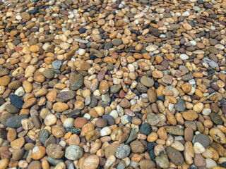 A bunch small colorful close up river rocks  texture background wallpaper.