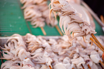 Grilled octopus on charcoal stove, Grilled squid on skewers, Barbecue (BBQ) squid, Favourite Thailand street food, Delicious street food.