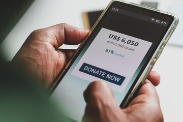 Person's decision making moment to donate to an organisation or individual. Crowdfunding fundraising for nonprofit organisations concept.