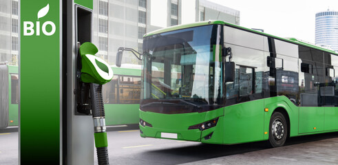 Biofuel filling station on a background of green city bus. Decarbonization of public transport