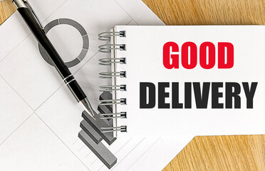GOOD DELIVERY text on notebook with chart on wooden background