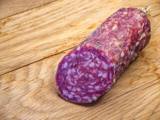 The salami’s rich color and visible fat content indicate a high-quality product.