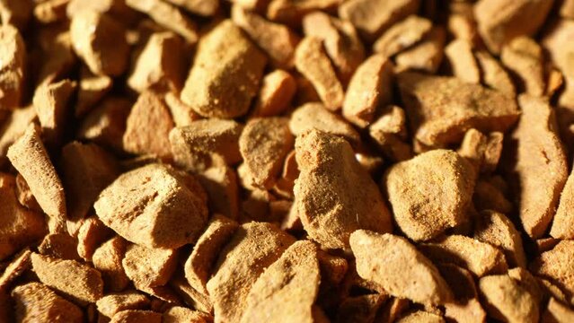 Captured in meticulous detail, the macro image unveils freeze-dried coffee, showcasing its textured landscape. Angular pieces reflect light, narrating the story of preservation through dehydration.
