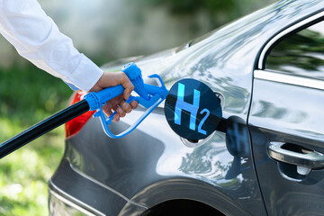 Man holds a hydrogen fueling nozzle. Refueling car with hydrogen fuel. Concept