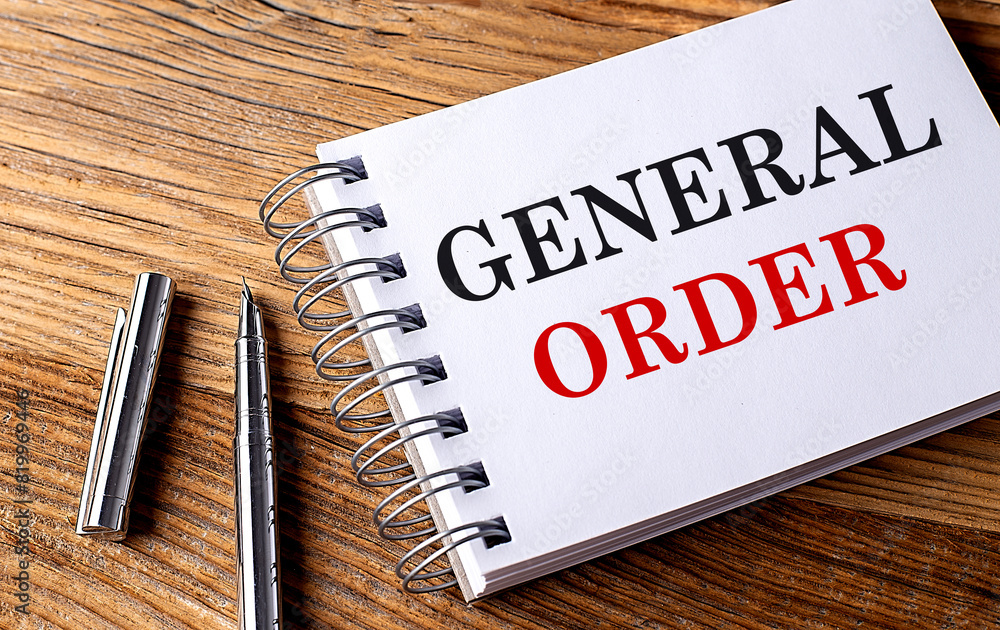 Poster general order text on notebook on wooden background