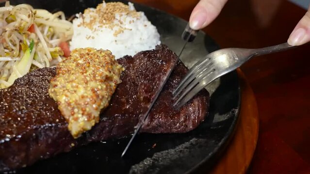 A succulent grilled steak, topped with Dijon mustard, served hot on a microgrill, ready to be enjoyed.