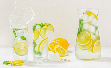 Glasses of lemonade with splash, Summer refreshing lemonade drink cocktail with ice, and lemon...