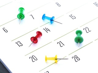 Push pins on a monthly calendar. Tools for marking events on a schedule and a close-up of a planner. Time management concept