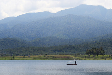 Hills with a person fishing in a lake