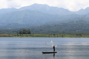 Hills with a person fishing in a lake