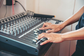 Production sound engineer woman hands adjusting volume equalizer voice, mixing console. DJ sound...