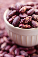 Uncooked variegated kidney bean seeds in bowl. Red and white dry beans