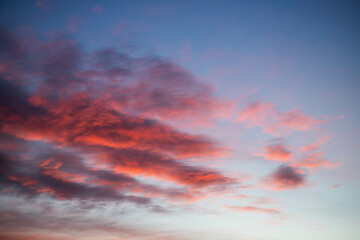 Obraz premium Sunset, red clouds on the background of the blue sky