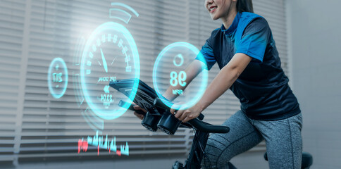 Cycling at home using a stationary exercise bike, with tracking heart rate for a healthy lifestyle graphical ui display technology, workout daily leisure routine, racing sport activity training.