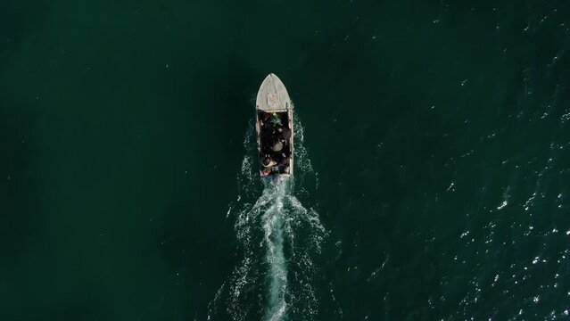 A boat carrying refugees across the ocean captured by aerial footage