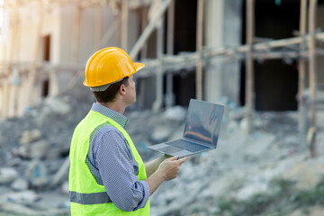 Male caucasian technician engineer construction worker using computer laptop for digital blueprint...