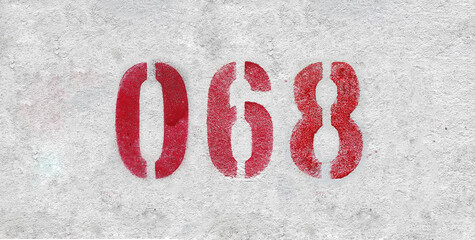 Red Number 068 on the white wall. Spray paint.
