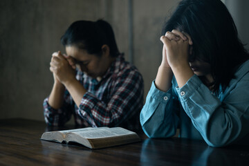 Hands clasped in prayer, Christians express their faith in God and worship Jesus Christ in the...