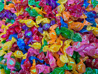 multi-colored small candies lie on the counter in a store